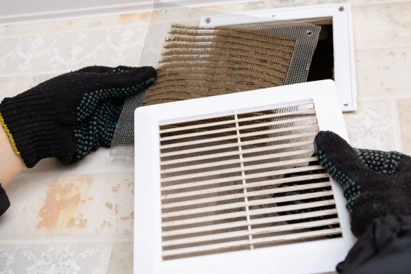 Close up of an extremely dirty and dusty white plastic ventilation air grille at from residential HVAC system.