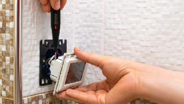 Person installing a smart thermostat in a residential home
