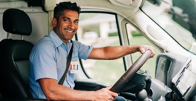 Technician smiling in a van.