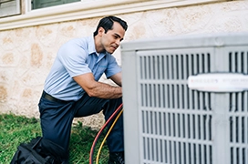 AireServ tech working on air conditioning unit.