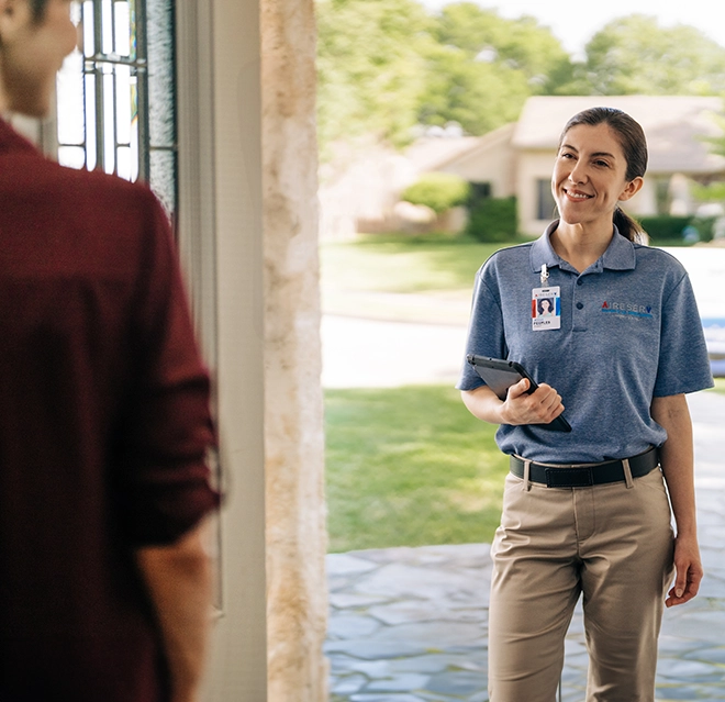 Aire Serv technician greets a customer at their door.