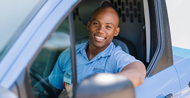Aire Serv professional driving an Aire Serv van.