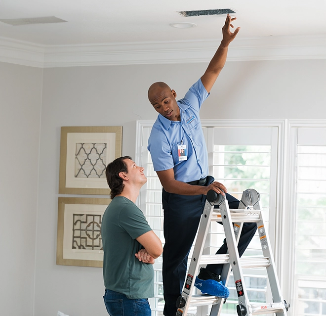 Aire Serv professional fixing air duct inside customers home.