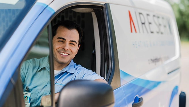 Aire Serv professional driving a van.
