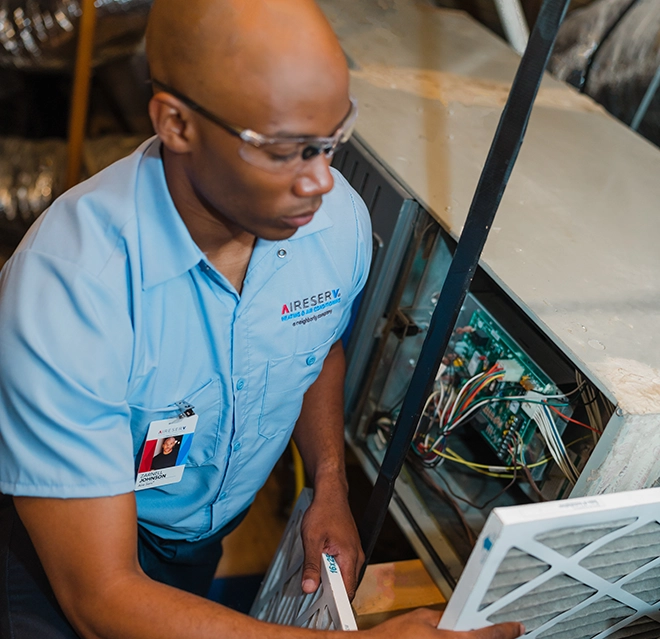 Aire Serv Professional working on a furnace.