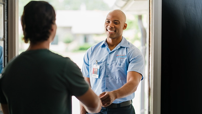 Aire Serv professional greeting a customer.