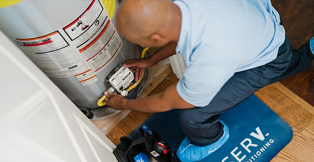 Aire Serv Professional working on a water heater.