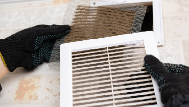 Close up of an extremely dirty and dusty white plastic ventilation air grille at from residential HVAC system.