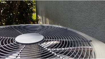 Closeup of AC condenser unit outside of a residential home